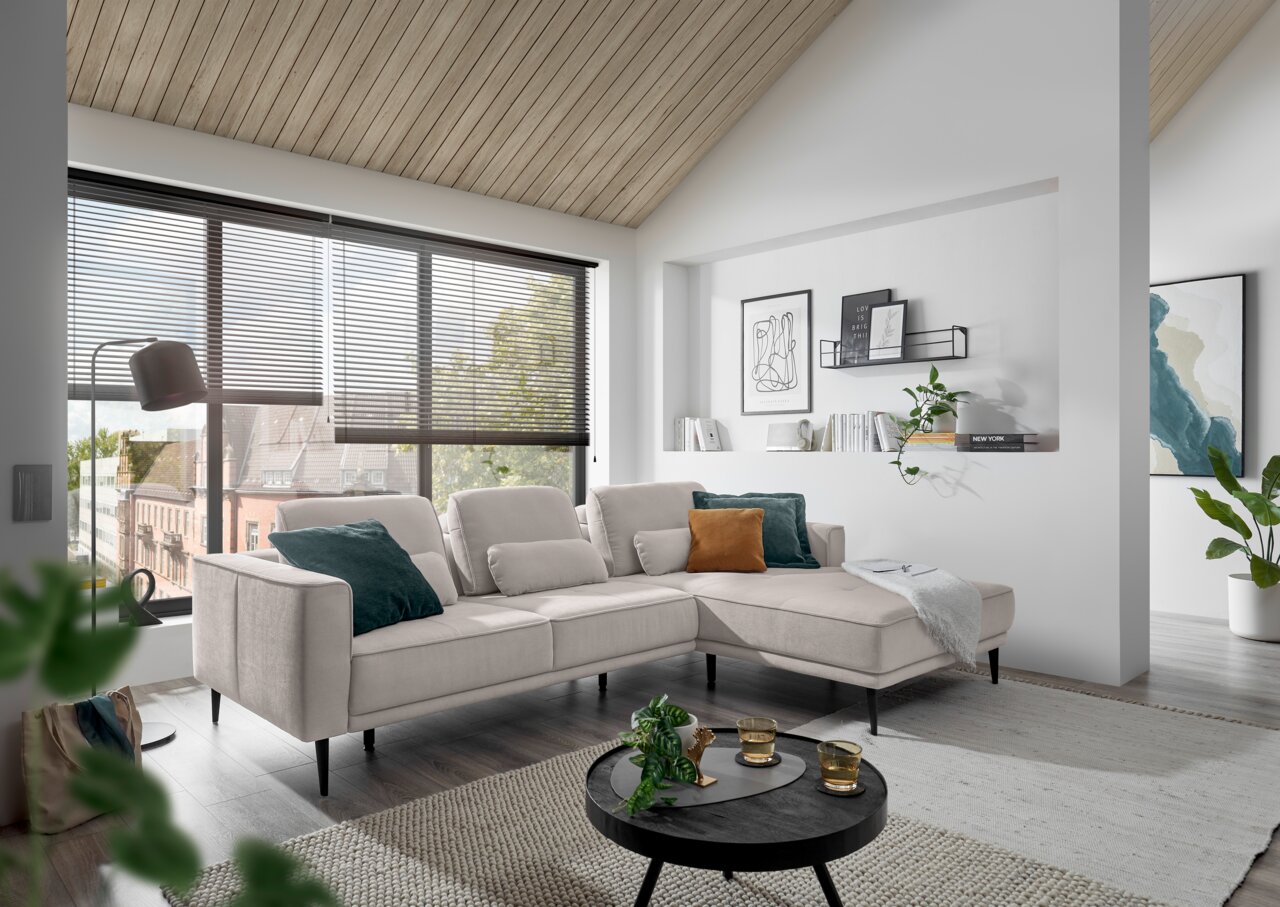 Moderne Rundecke in hellem Wohnzimmer mit großen Fenstern, seitliche Perspektive