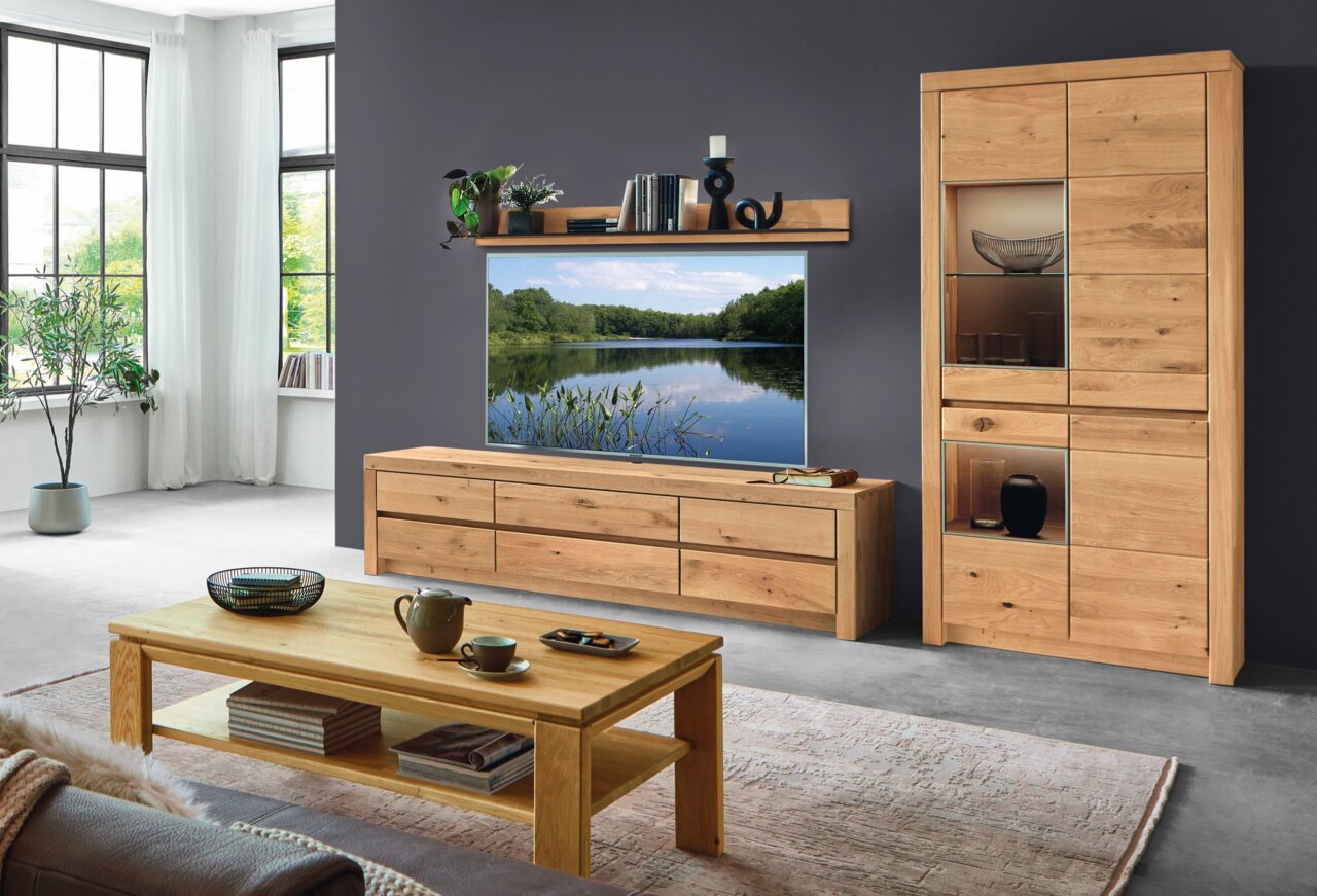 Wöstmann Markenmöbel Wandcombinatie SOLEO 3000 Zicht op de woonkamer met een moderne houten wandmeubelcombinatie, bestaande uit een lowboard, een wandrek en een vitrinekast. Aanzicht van voren.