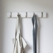 Moderne Wandgarderobe mit mehreren Haken, frontal fotografiert, mit aufgehängten Stoffen.