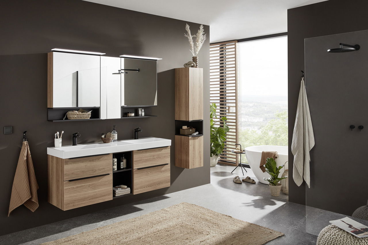 Moderne Badkombination mit Holzoptik, bestehend aus einem Doppelwaschtisch mit Spiegeln und Schränken, in einem stilvoll eingerichteten Badezimmer mit Blick auf die Natur.