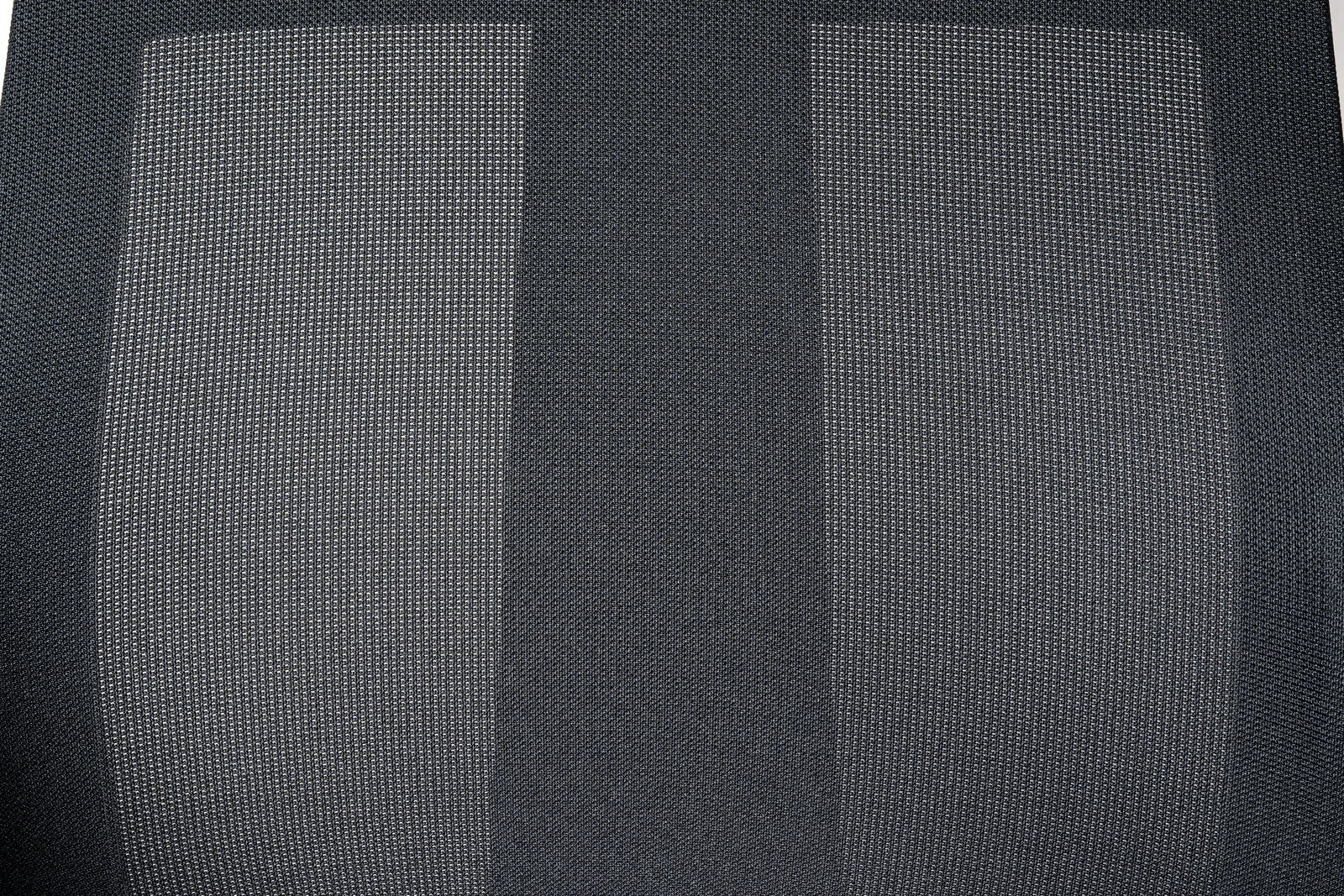 Nahaufnahme der Rückenlehne eines Drehstuhls mit grauem Netzstoff, von vorne betrachtet.