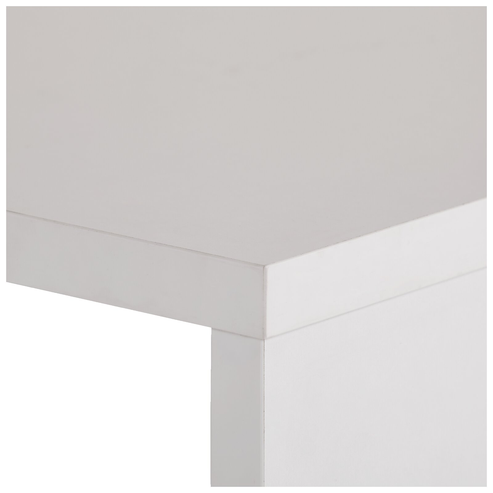 Close-up van de hoek van een witte tafel met strak blad en poot, schuin van boven gefotografeerd (driekwartperspectief).