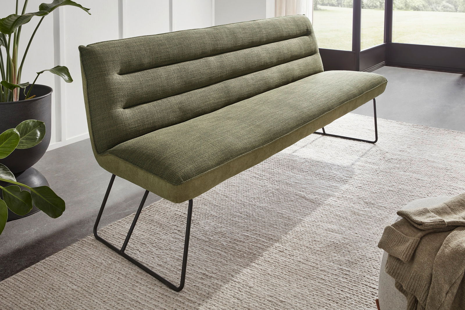 Grüne Bank mit modernem Design und Metallbeinen, seitliche Perspektive