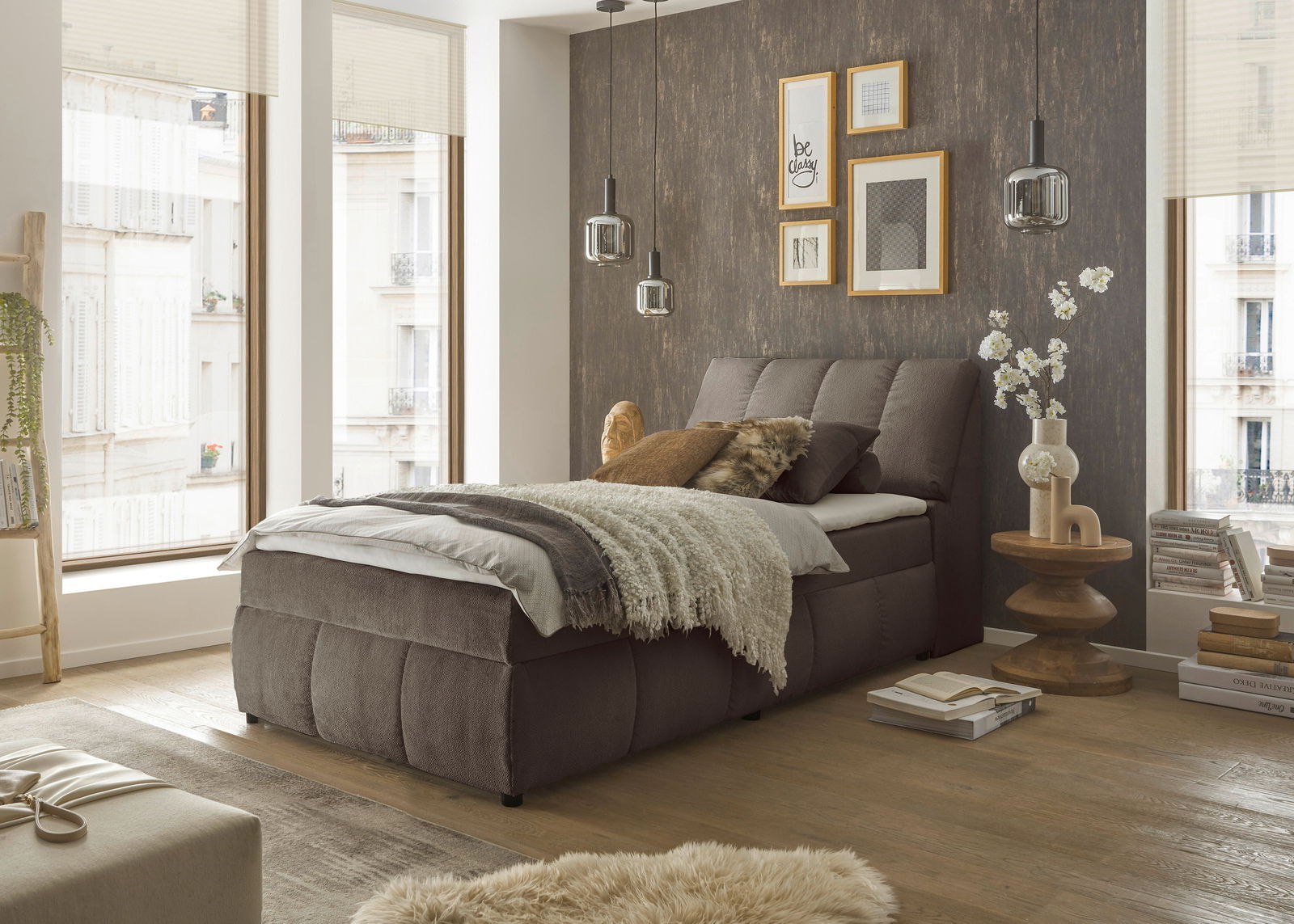 Gemütliches Boxspringbett in einem stilvoll eingerichteten Schlafzimmer, seitliche Perspektive