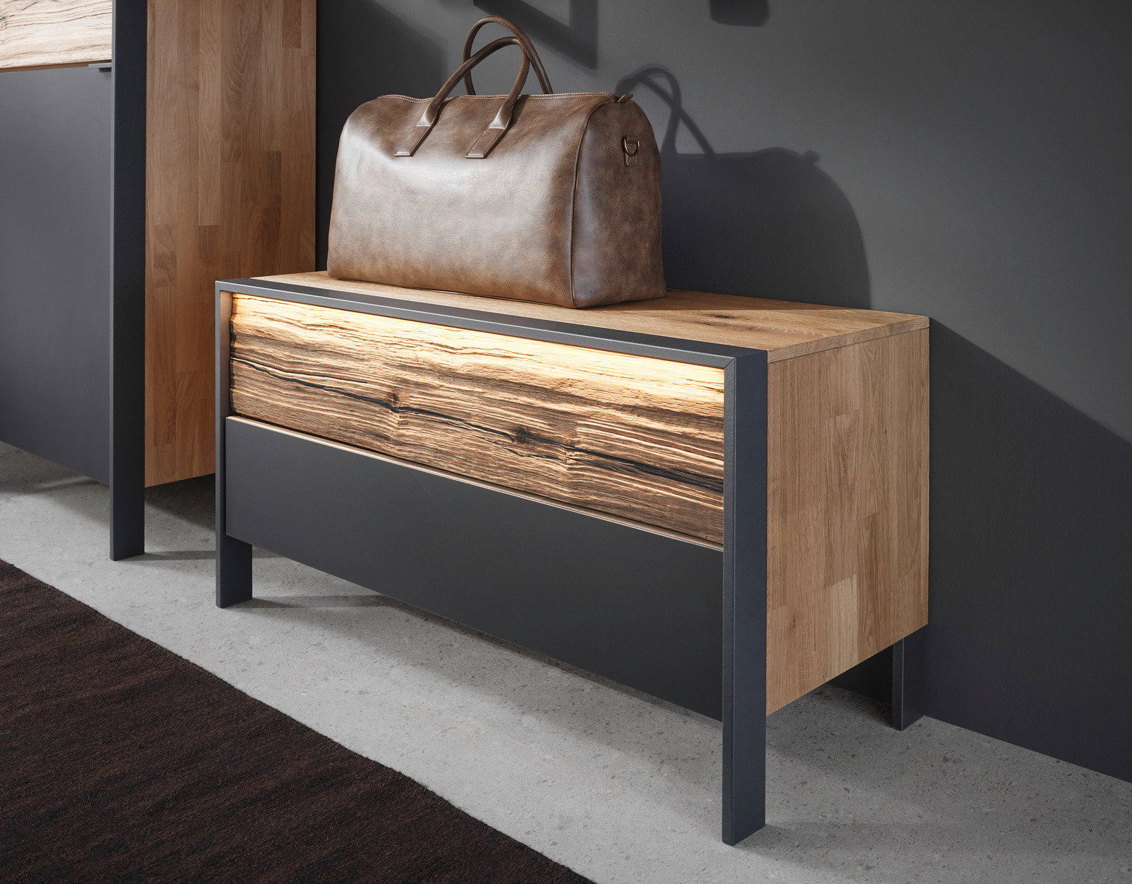 Garderobenbank aus Holz mit Metallrahmen, seitliche Perspektive, darauf eine braune Ledertasche