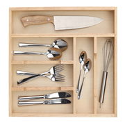 Vogelperspektive auf einen Besteckkasten aus Holz mit Messer, Löffeln, Gabeln und Schneebesen.