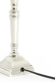 Nahaufnahme eines eleganten, vernickelten Lampenfußes mit quadratischer Basis und Kabelanschluss, seitliche Perspektive.