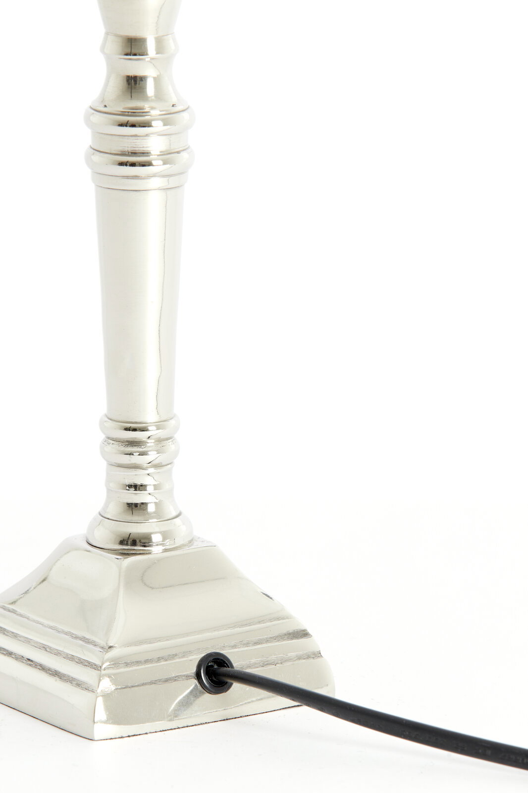 Nahaufnahme eines eleganten, vernickelten Lampenfußes mit quadratischer Basis und Kabelanschluss, seitliche Perspektive.