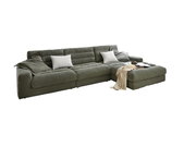 Grüne Longchairkombination in modernem Wohnzimmer mit Blick auf das Meer durch große Fenster, dekoriert mit Kissen und Decke, fotografiert aus einer leicht erhöhten Perspektive.