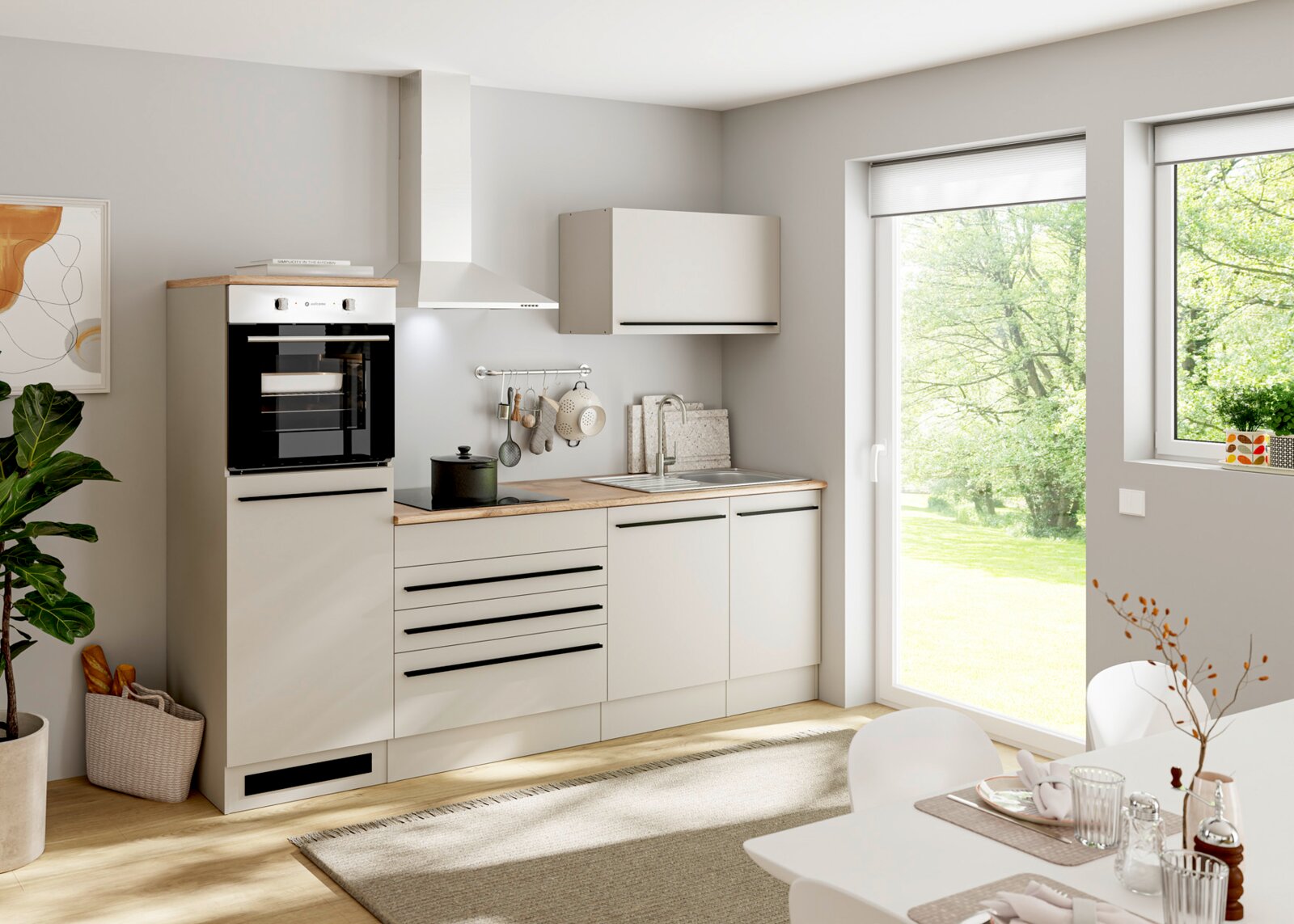 Moderne compacte keuken in mat wit met houtkleurig werkblad, zwarte handgrepen, inbouwoven, kookplaat en spoelbak, schuin van voren weergegeven in een lichte eetruimte