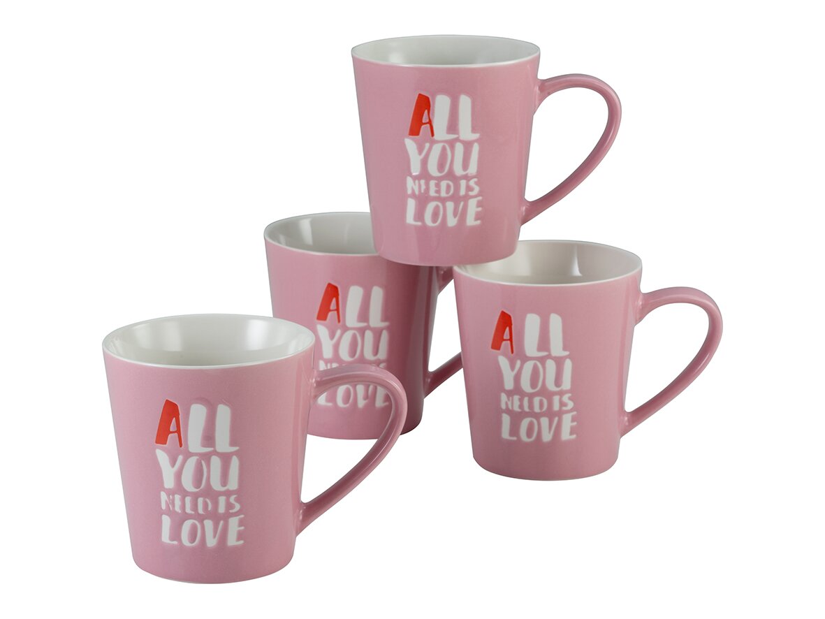 Vier rosafarbene Keramik-Kaffeebecher mit weißem Innenraum und Aufdruck „ALL YOU NEED IS LOVE“, schräg von vorn in Gruppenanordnung fotografiert