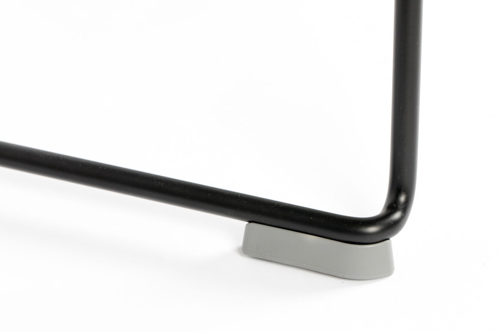 Nahaufnahme eines schwarzen Stuhlbeins mit grauem Bodenschutz, seitliche Perspektive