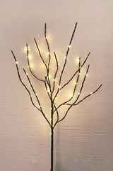 LED-Zweig mit warmweißen Lichtern, frontal fotografiert vor einer strukturierten Wand.