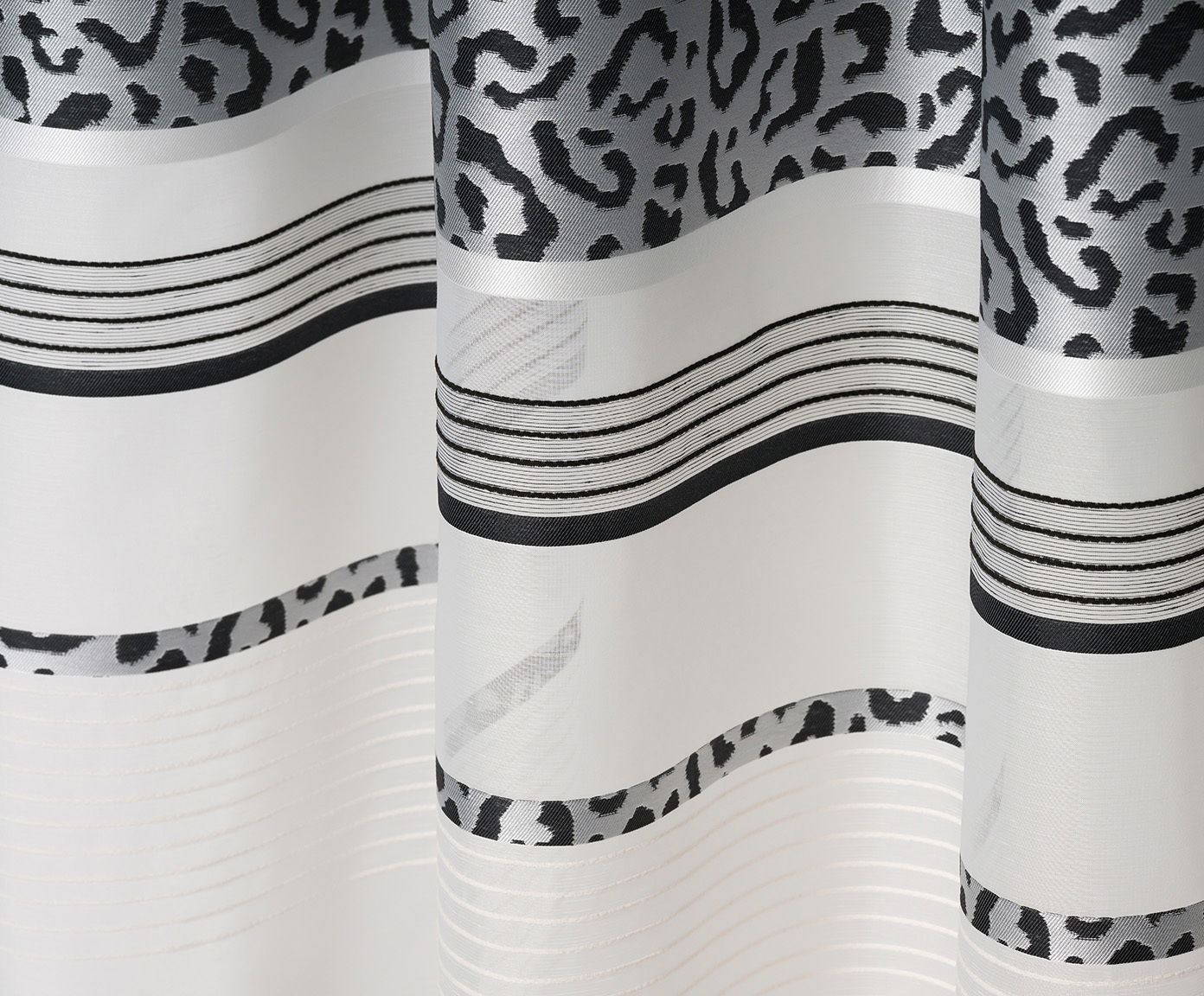 GÖZZE Schlaufenvorhang LEONA Nahaufnahme eines Vorhangs mit verdeckten Schlaufen, 140x245cm, mit schwarz-weißen Leopardenmuster und horizontalen Streifen.