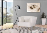 Moderner cremefarbener Sessel mit Holzbeinen in einem stilvollen Wohnzimmer, seitliche Perspektive.