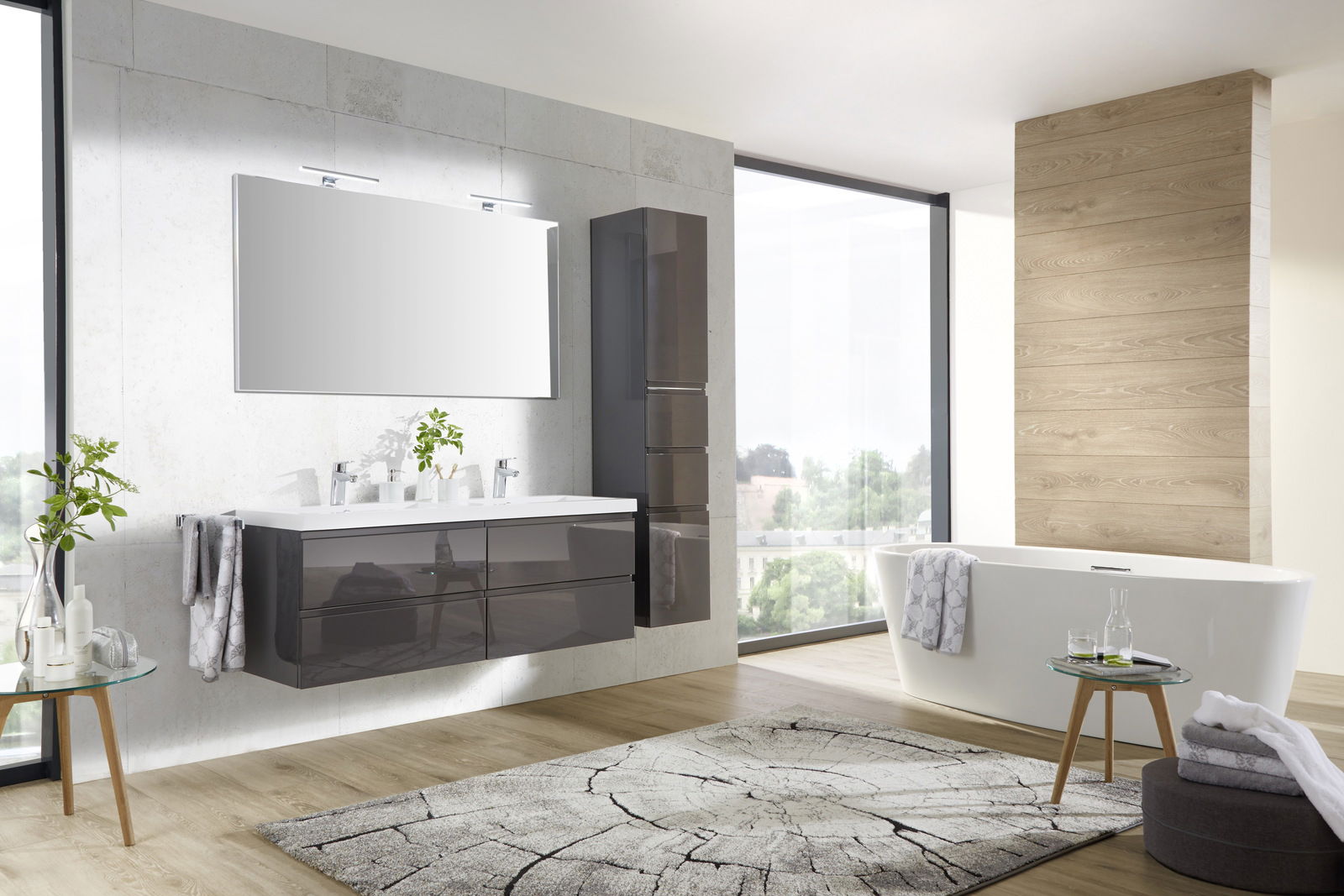 Moderne Badkombination mit Doppelwaschbecken, großem Spiegel und freistehender Badewanne in einem hellen, stilvollen Badezimmer. Perspektive von vorne links.