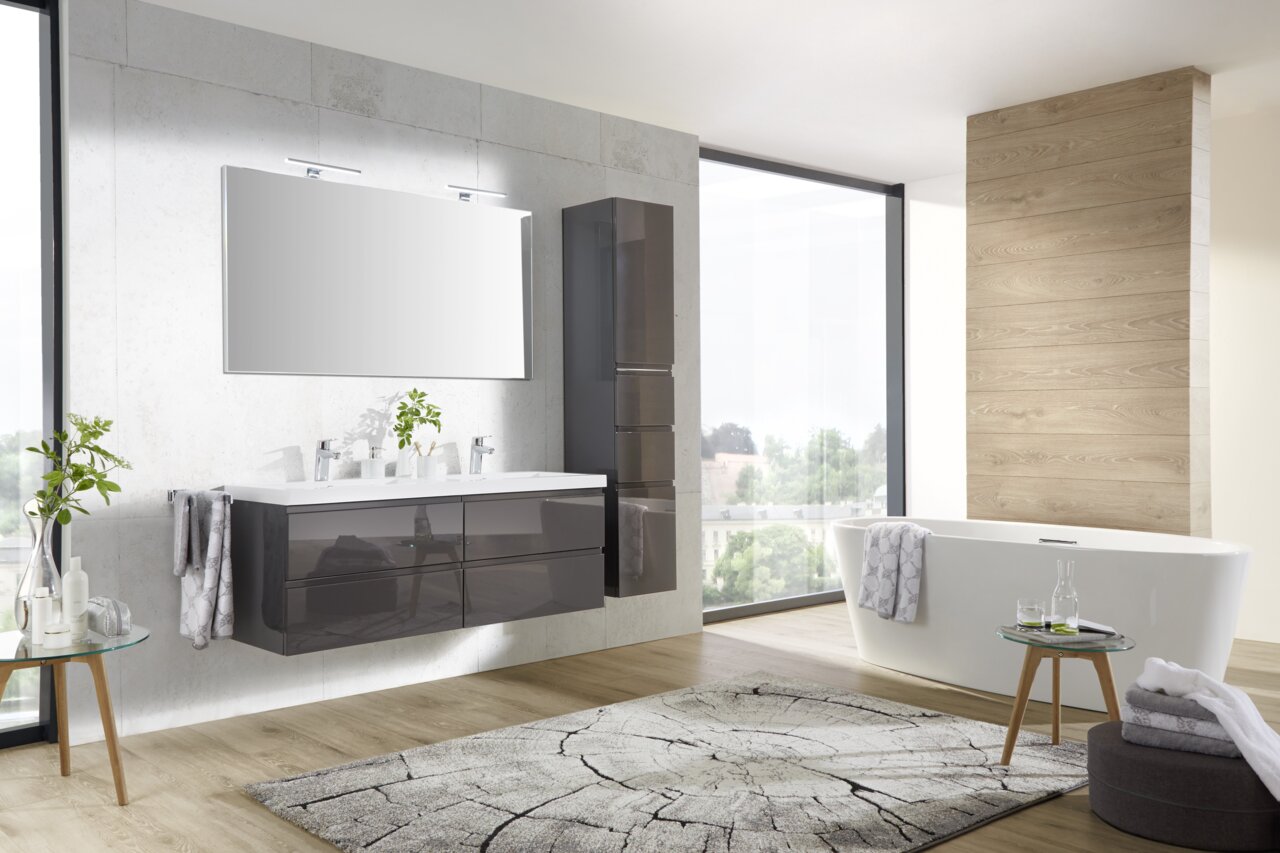 Moderne badkamercombinatie met dubbele wastafel, grote spiegel en vrijstaand bad in een lichte, stijlvolle badkamer. Aanzicht van linksvoor.