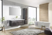 Moderne Badkombination mit Doppelwaschbecken, großem Spiegel und freistehender Badewanne in einem hellen, stilvollen Badezimmer. Perspektive von vorne links.