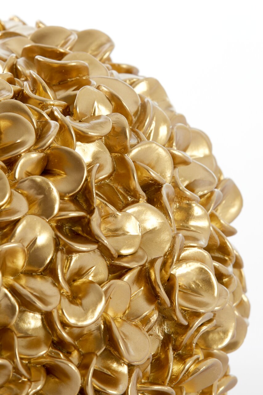 Nahaufnahme einer goldenen Vase mit blattähnlicher Struktur, seitliche Perspektive.