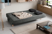 Schlafsofa 3 Sitzer in einem modernen Wohnzimmer, von oben betrachtet, mit grauem Stoffbezug, zwei schwarzen Kissen und einer beigen Decke.