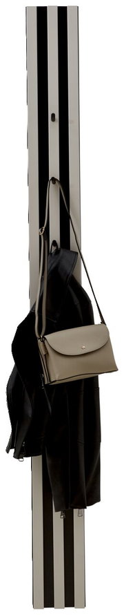 Garderobenpaneel mit vertikalen schwarzen und weißen Streifen, darauf hängen eine schwarze Jacke und eine beige Handtasche. Frontalansicht.