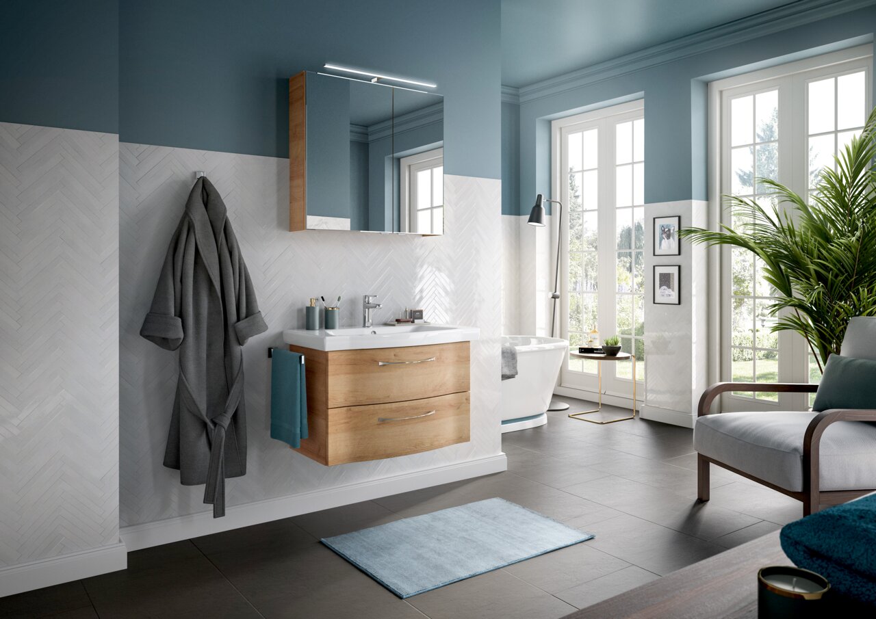 Moderne Badezimmeransicht mit Waschtischlösung in Holzoptik, Spiegel und Badewanne, seitliche Perspektive