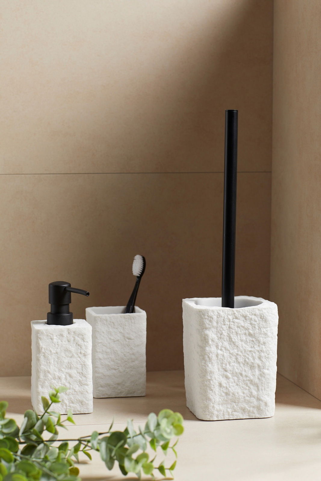 Seifenspender Modell Villata in Weiß, aus seitlicher Perspektive fotografiert, neben einem Zahnbürstenhalter und einer Toilettenbürste.