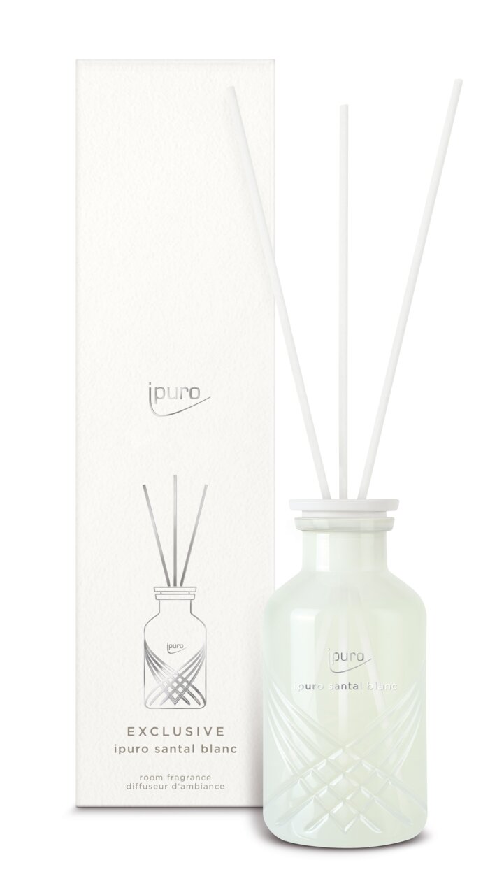 Ipuro Santal Blanc kamerparfum in een elegante glazen fles met witte stokjes, hiernaast afgebeeld naast de verpakking.