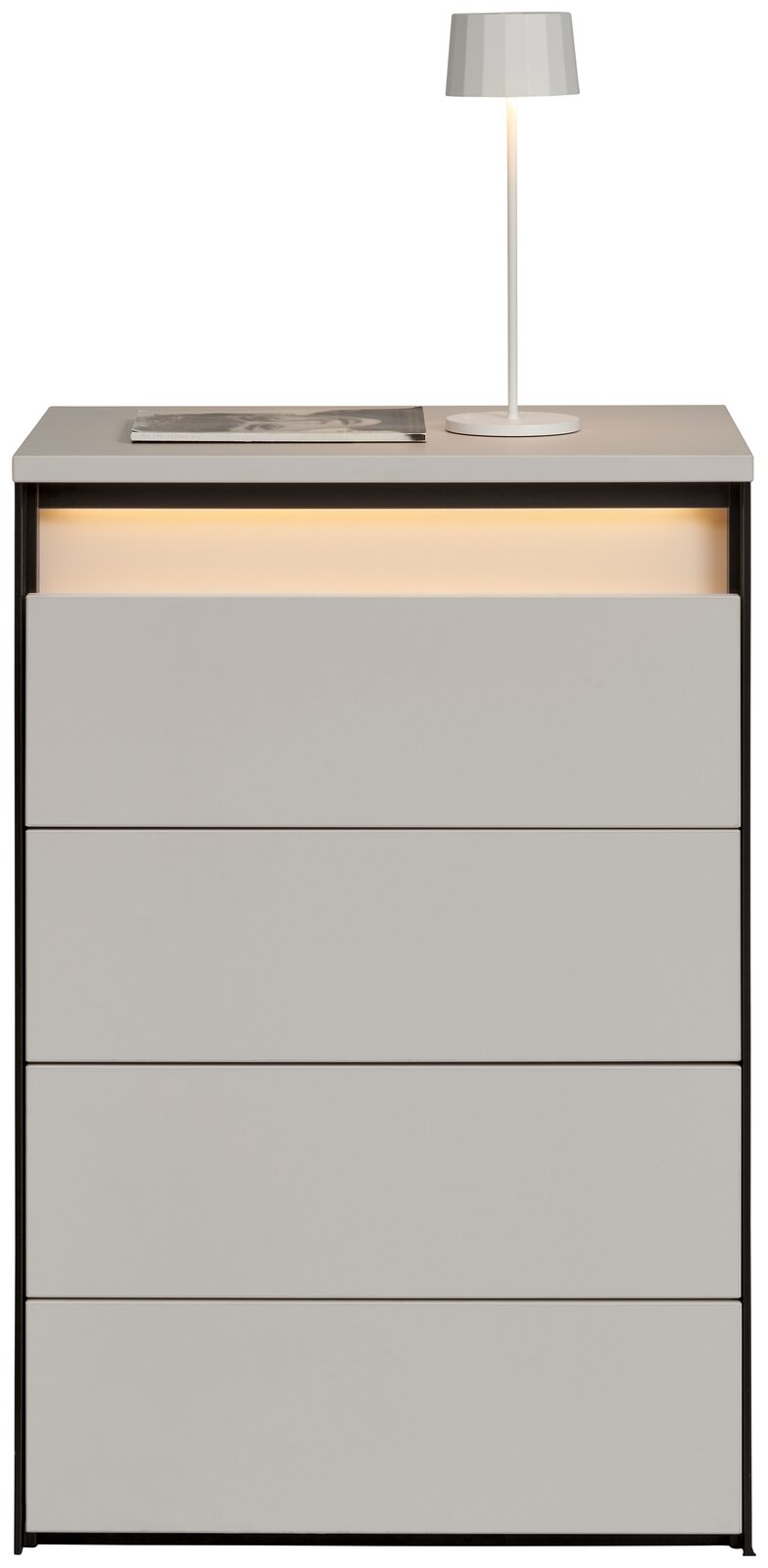 Hochkommode mit vier Schubladen, grauer Oberfläche und integrierter Beleuchtung, frontal betrachtet. Auf der Oberseite steht eine weiße Lampe und ein Buch.