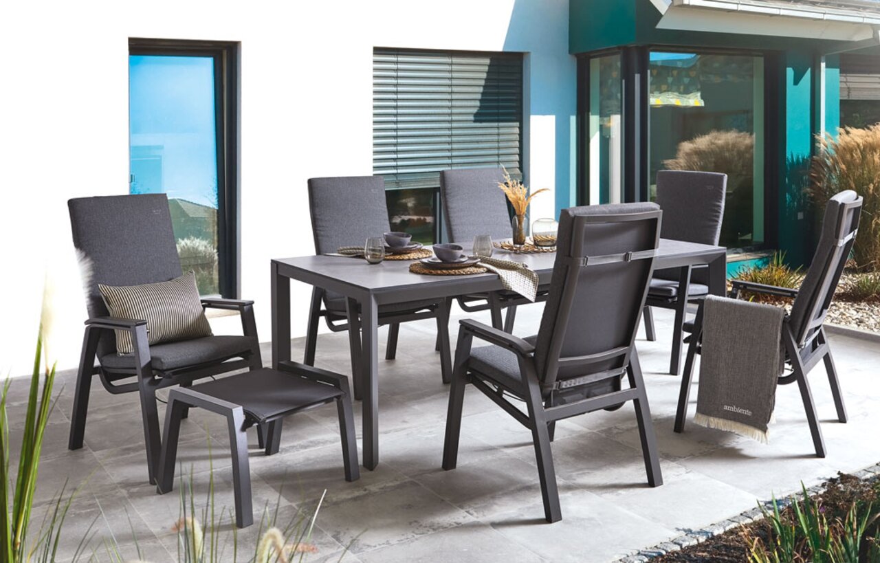 Gartenmöbel-Set mit Hochlehnsesseln und Tisch auf einer Terrasse, seitliche Perspektive