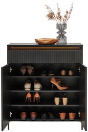 Moderner Schuhschrank mit geöffneter Tür, gefüllt mit verschiedenen Schuhen, dekoriert mit einer Holzschale und einer Vase mit getrockneten Gräsern auf der Oberseite, Frontalansicht.