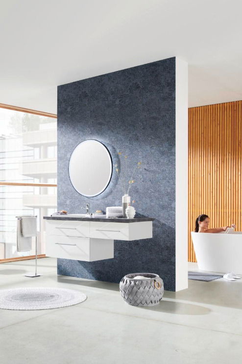 Moderne Badkombination mit weißem Waschtisch und rundem Spiegel, seitliche Perspektive