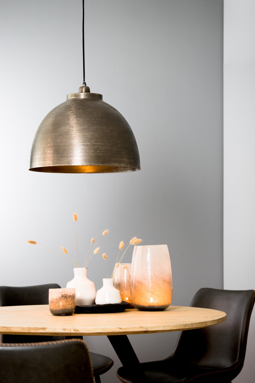 Hanglamp KYLIE in antieke metaallook boven een ronde houten tafel met decoratie, zijaanzicht