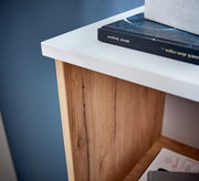 Nahaufnahme eines Aktenschranks mit weißer Oberseite und Holzmaserung, von oben betrachtet.