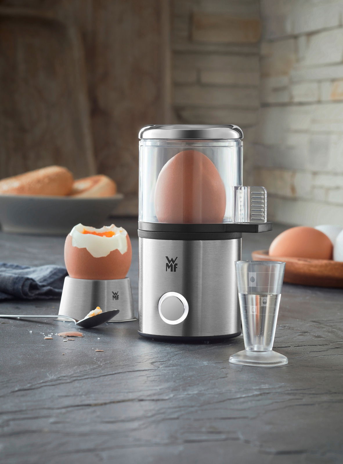 Eierkocher MyEgg Küchenminis in Edelstahloptik, frontal abgebildet mit einem Ei im Kocher und einem gekochten Ei daneben.