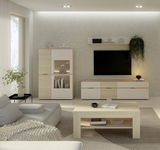 Moderne Wohnzimmeransicht mit einer hellen Vitrine, die links im Bild steht. Die Vitrine hat eine Glasfront und ist Teil eines stilvollen, minimalistischen Wohnzimmers mit einem großen Sofa, einem Couchtisch und einem Fernseher an der Wand.