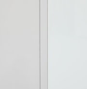 Nahaufnahme eines weißen Aufsatzschranks mit klaren Linien und minimalistischer Gestaltung, seitliche Perspektive.