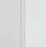 Close-up van een witte opzetkast met strakke lijnen en een minimalistisch ontwerp, gezien vanaf de zijkant.