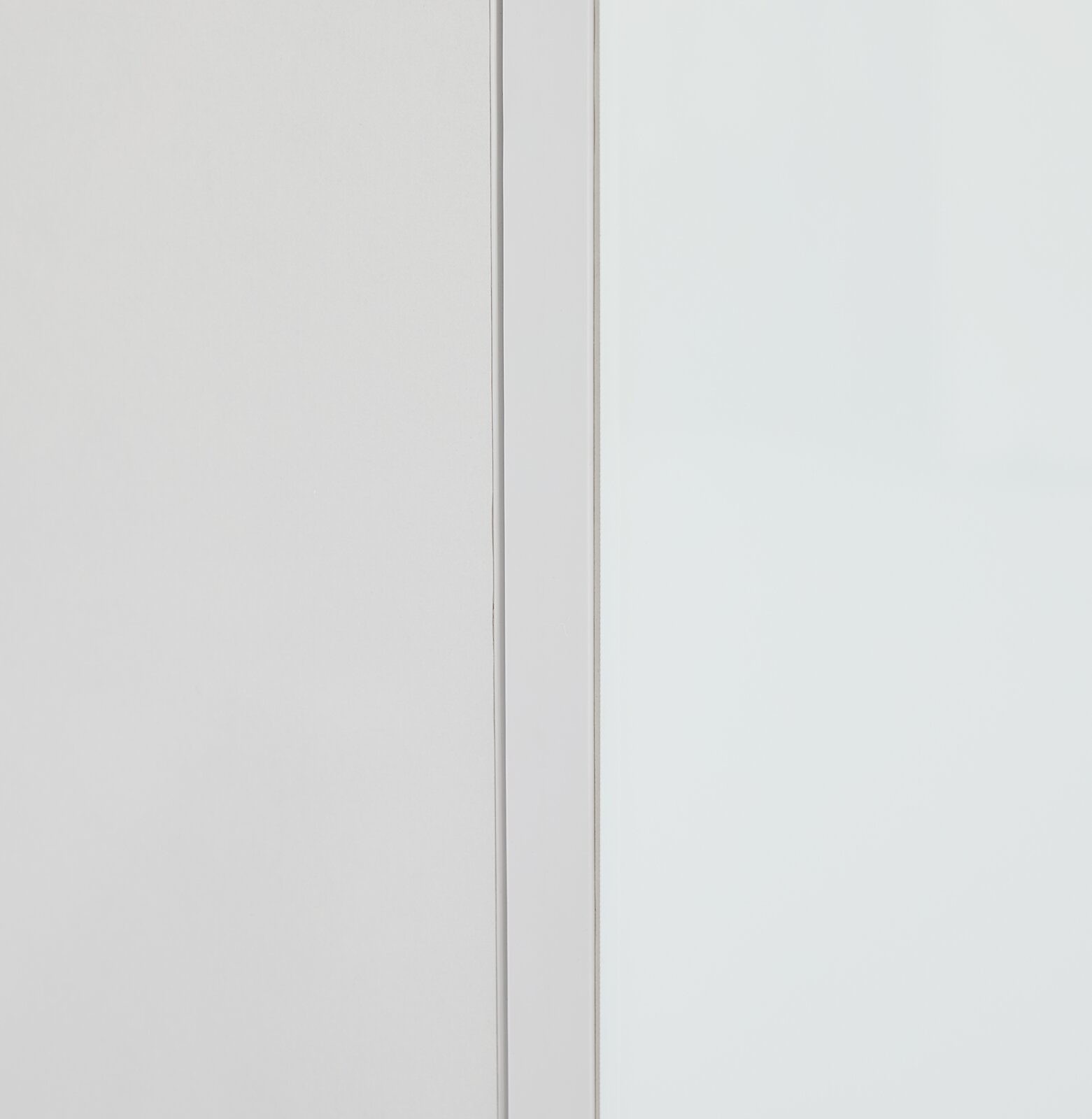 Close-up van een witte opzetkast met strakke lijnen en een minimalistisch ontwerp, gezien vanaf de zijkant.