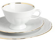 Weiße Porzellan-Teetasse mit Untertasse und Dessertteller, goldfarbenem Rand und geschwungenem Relief, schräg von vorne (3/4-Ansicht) fotografiert