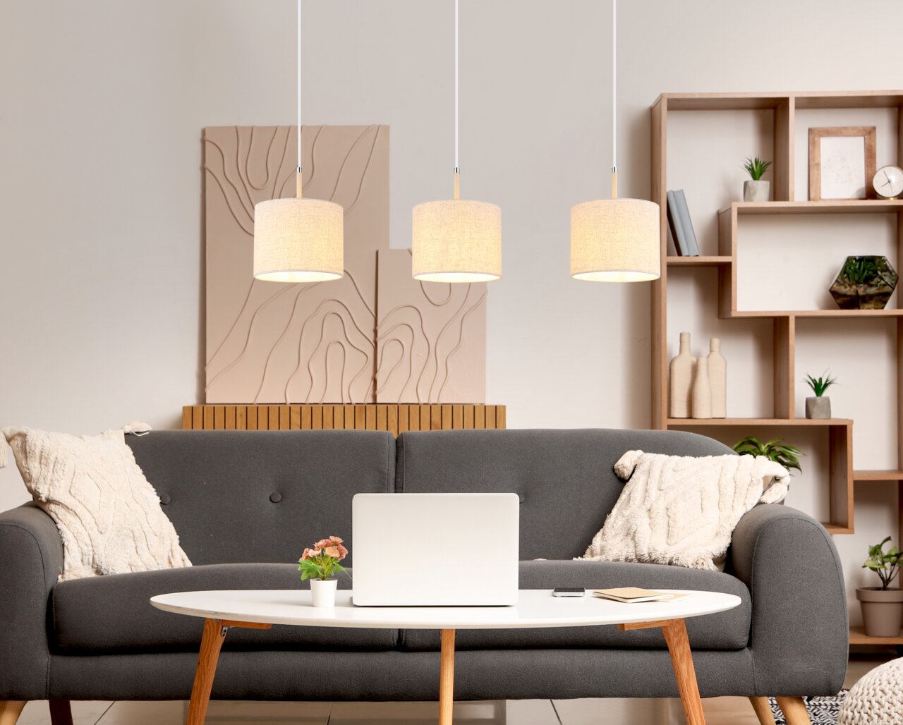 Drei moderne Hängeleuchten in einem gemütlichen Wohnzimmer, frontal betrachtet.