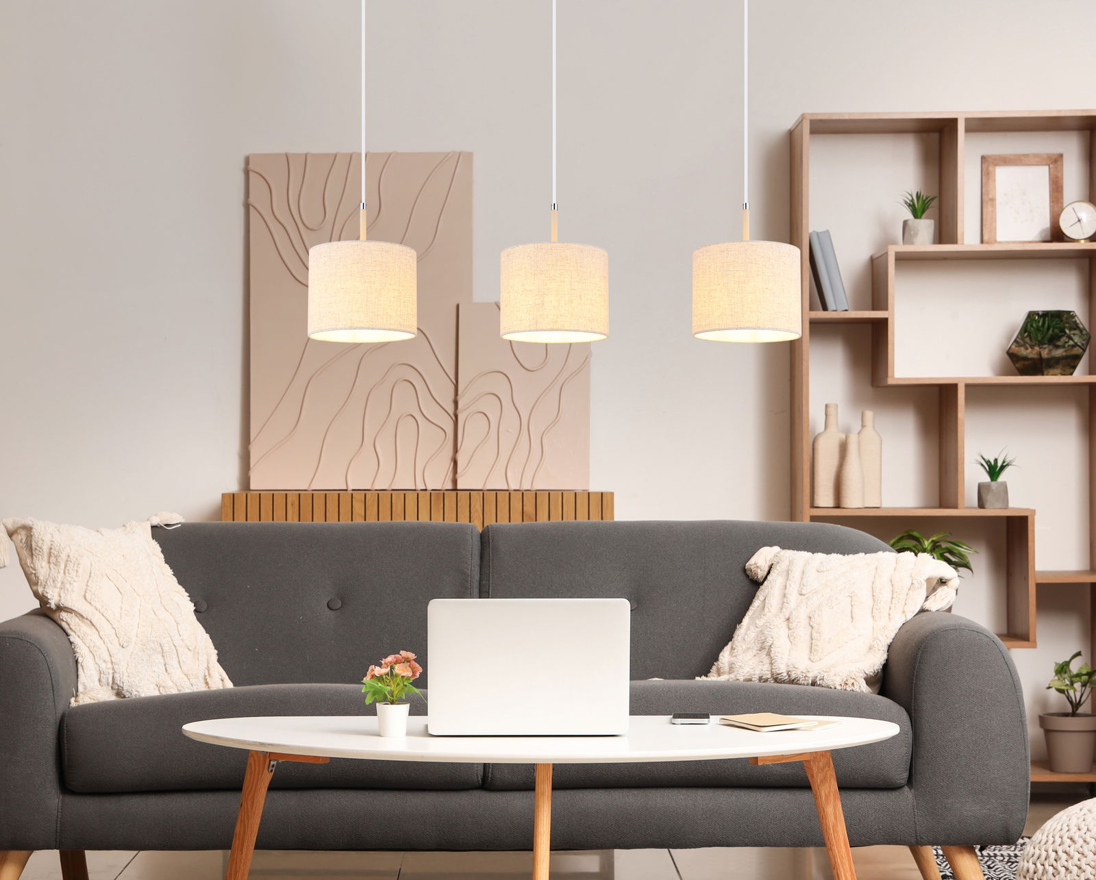 Drei moderne Hängeleuchten in einem gemütlichen Wohnzimmer, frontal betrachtet.