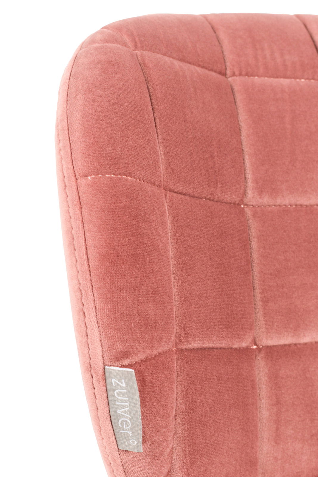 Nahaufnahme eines rosafarbenen, gepolsterten Stuhlrückens mit quadratischem Muster und einem Etikett der Marke Zuiver.