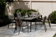 Gartensessel in einem modernen Garten-Set mit Tisch und mehreren Stühlen, seitliche Perspektive