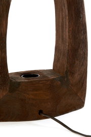 Nahaufnahme einer Tischleuchte aus dunklem Holz mit sichtbarer Kabeldurchführung, seitliche Perspektive.