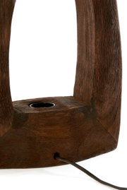 Nahaufnahme einer Tischleuchte aus dunklem Holz mit sichtbarer Kabeldurchführung, seitliche Perspektive.