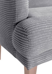 Nahaufnahme eines grauen, gerippten Sofas mit Holzbeinen, Perspektive von der Seite