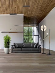 Modernes Wohnzimmer mit grauem Sofa, hängenden Design-Leuchten und Stehlampe vor großer Fensterfront; Perspektive: frontale Ansicht auf das Sofa auf Augenhöhe.