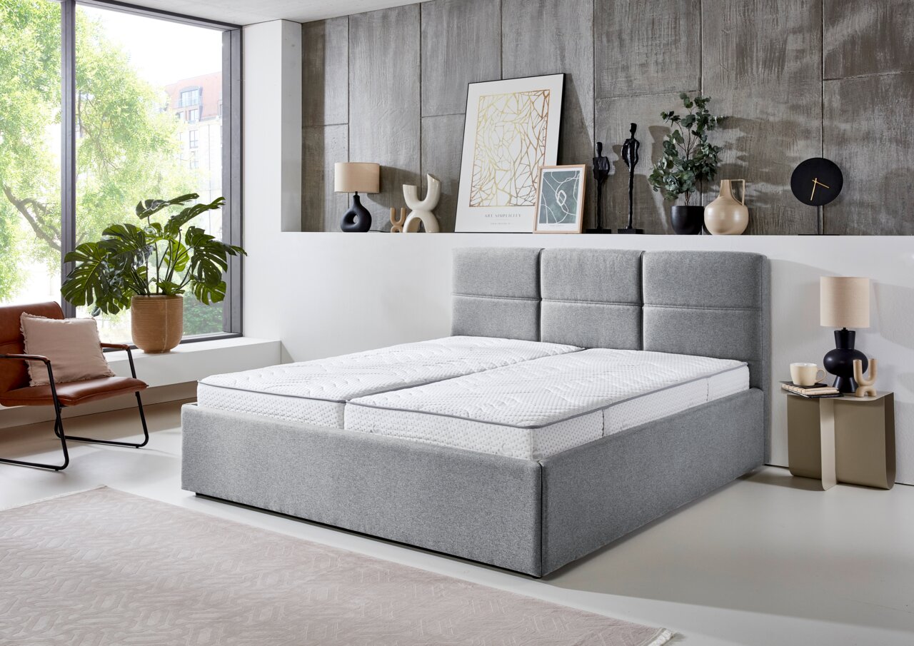 Graues Polsterbett 180x200 in modernem Schlafzimmer, seitliche Perspektive