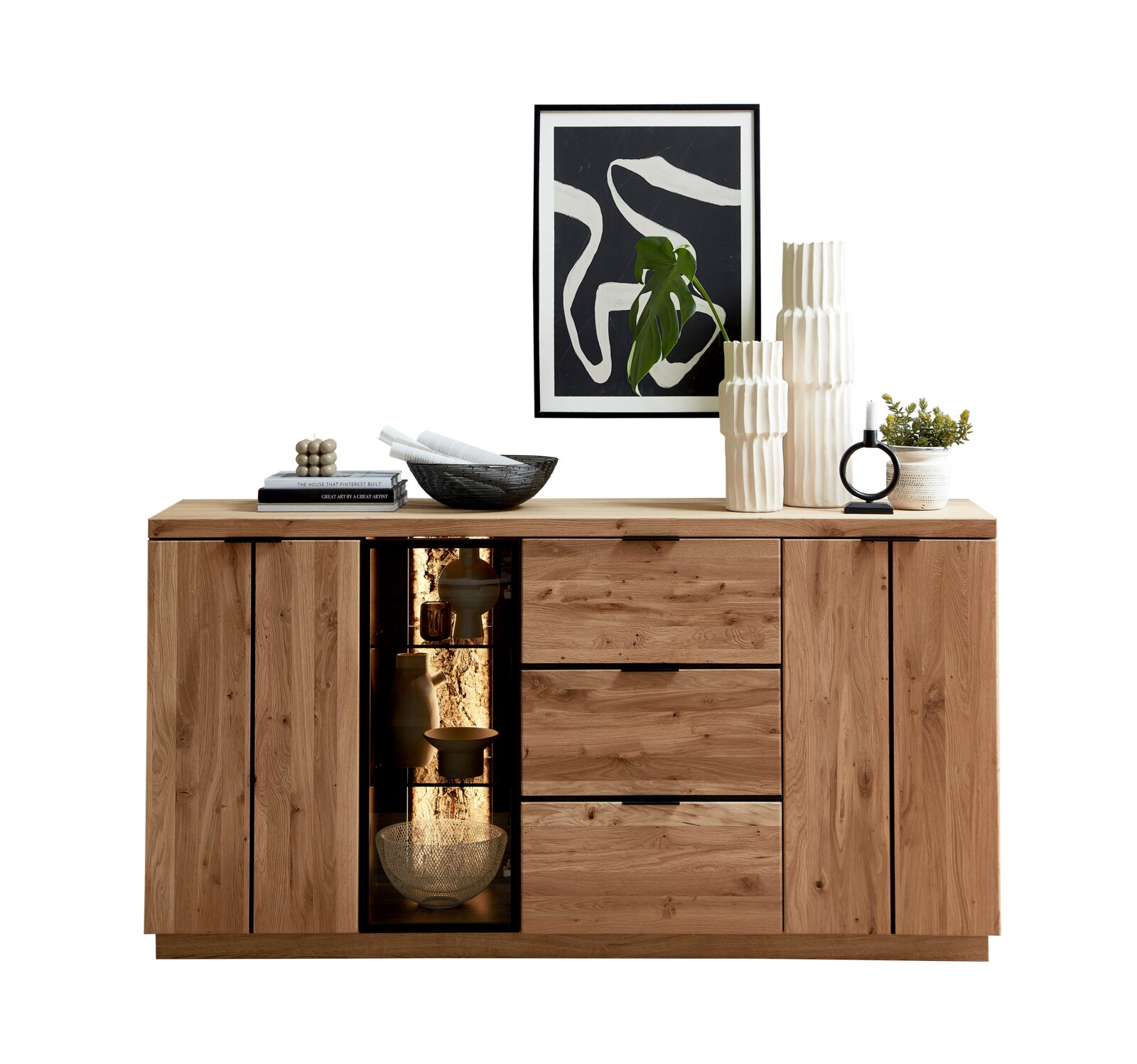 Cantus Dressoir DONNA Houten dressoir in natuurlijke eikenlook met deuren, lades en glazen vitrinekast met warme verlichting, frontaal aanzicht, gestyled met vazen en wandkunst op witte achtergrond